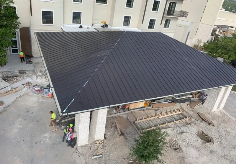 Metal roofing installation team working on a commercial building in San Leandro